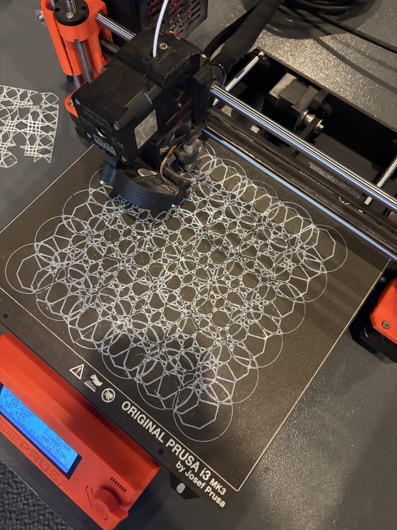 A 3D printer mid-print of a lace panel on the build plate